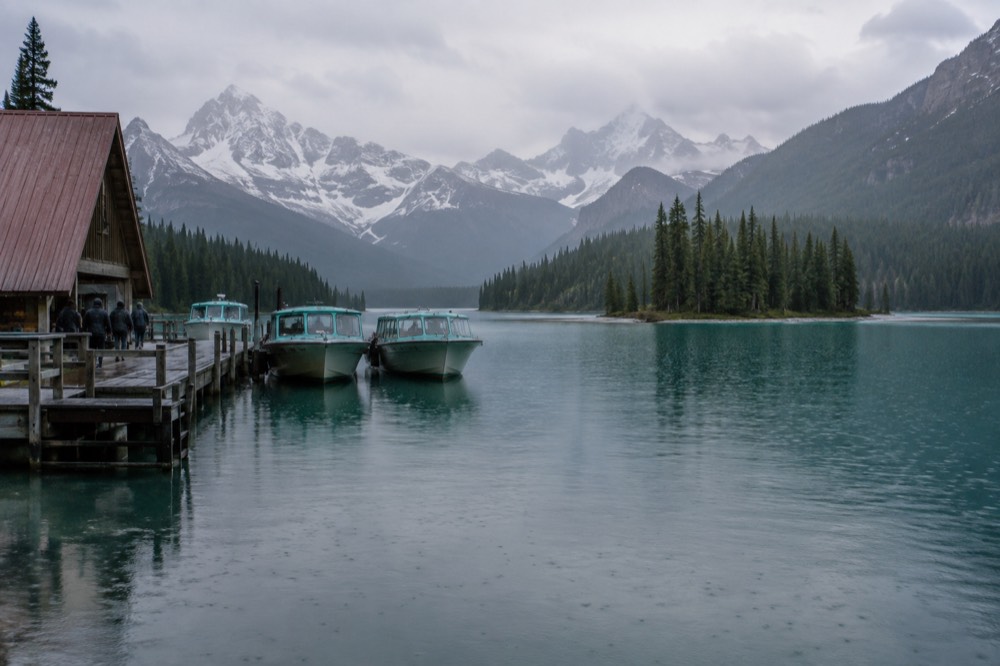 A turquoise lake stretching toward forested slopes with a small island near the far shore