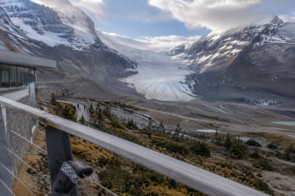 A wide viewpoint over the Athabasca Glacier with the icefield rising behind it under scattered clouds