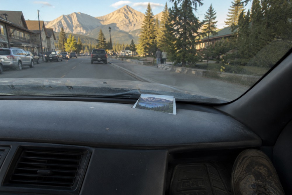 A park pass displayed on the dashboard of a car parked at a scenic mountain viewpoint