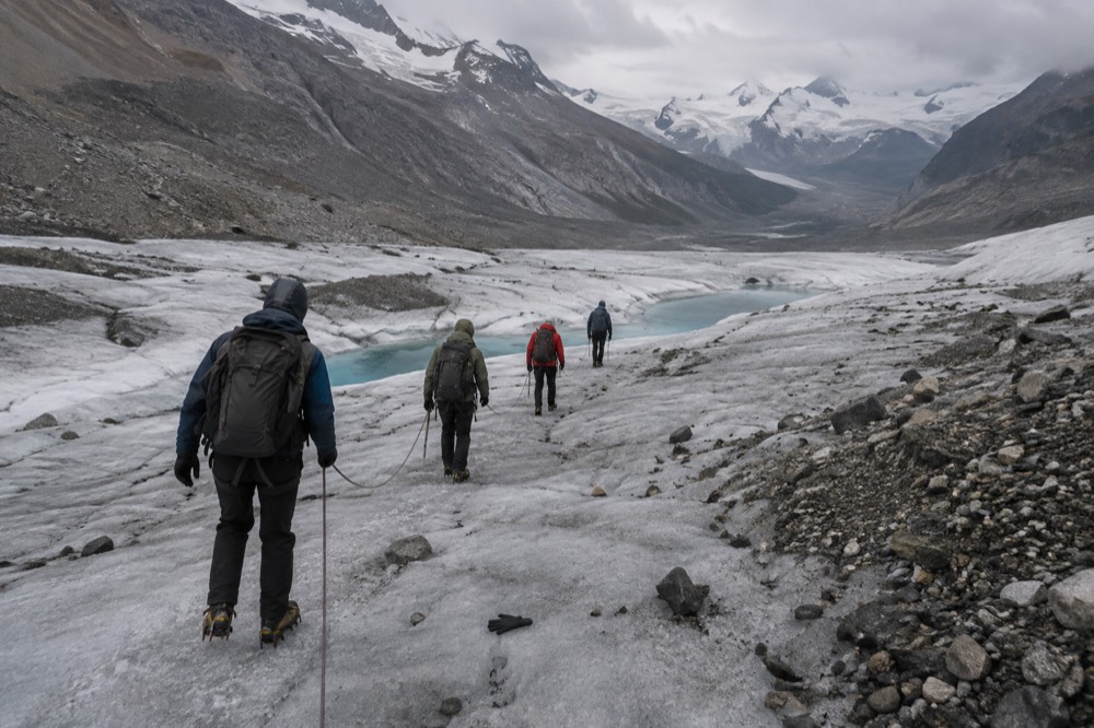 Guided hikers in crampons walking across the crevassed surface of the Athabasca Glacier