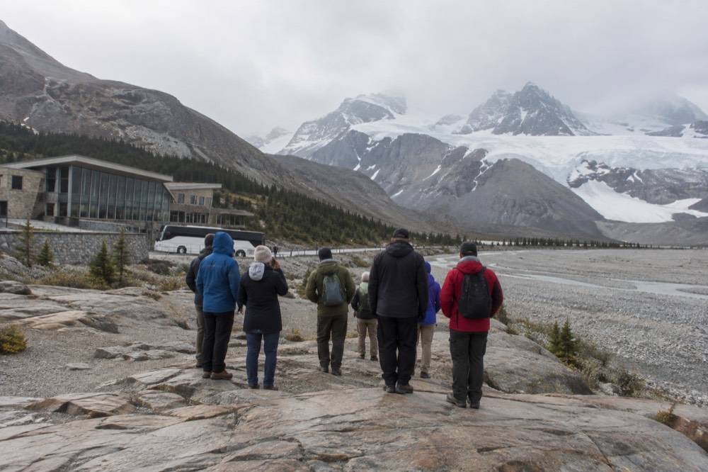 A guided tour group at a roadside viewpoint on the Icefields Parkway