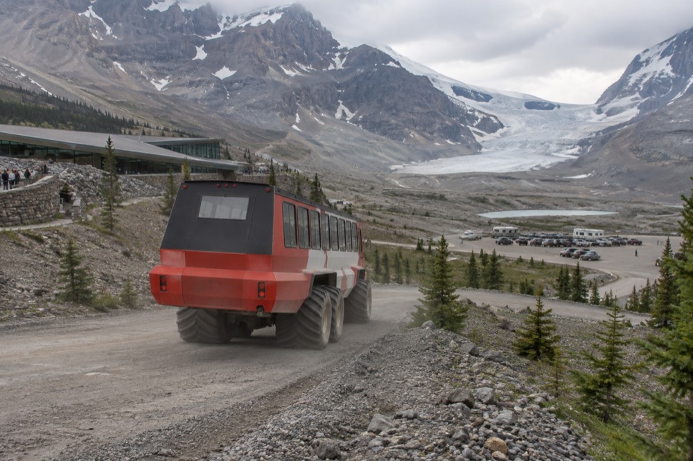 An Ice Explorer vehicle descending the steep access road toward the Athabasca Glacier