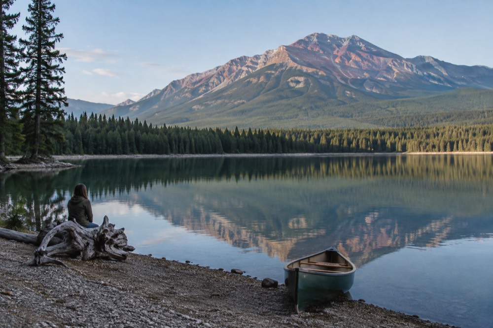 A calm lake reflecting mountain peaks inside Jasper National Park