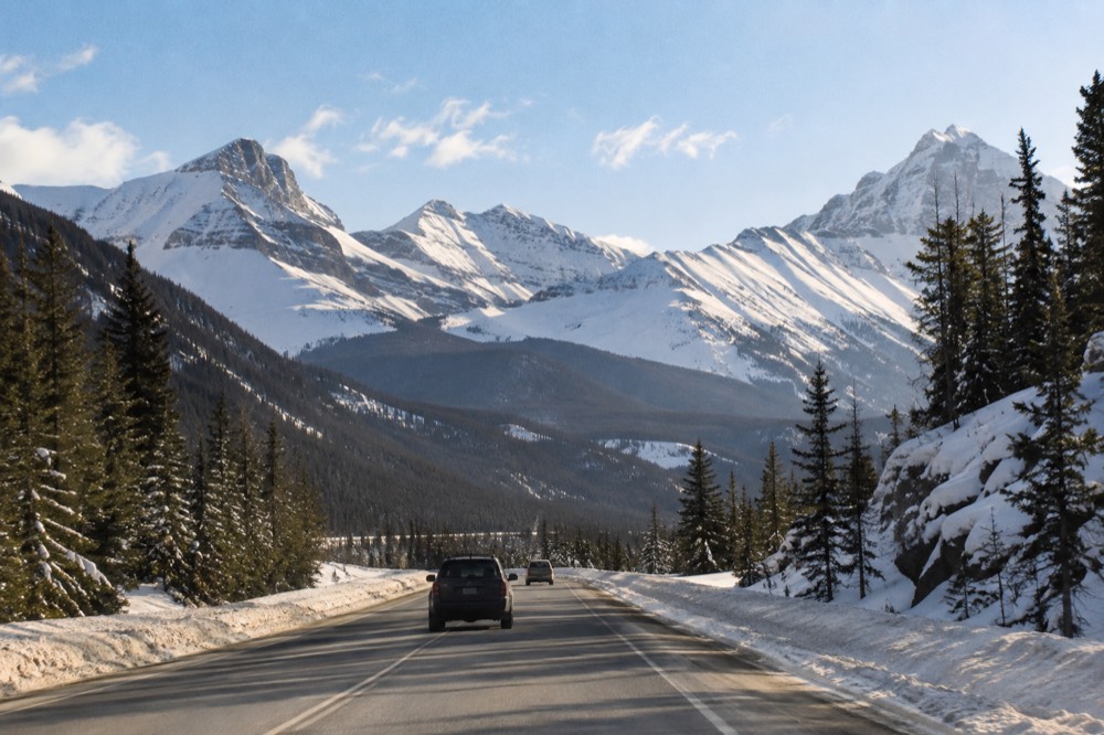A glacier road winding between tall snow-covered mountain peaks