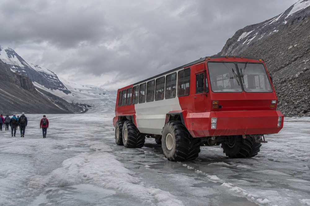 An all-terrain vehicle parked on a wide glacier ice field