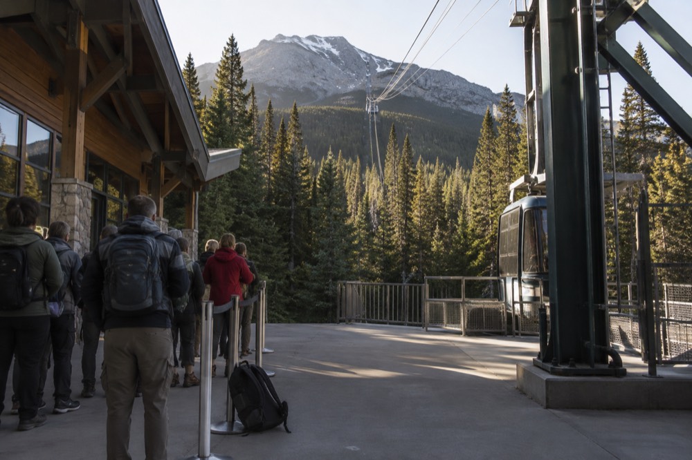 Queue of visitors waiting at a tramway station platform in morning light