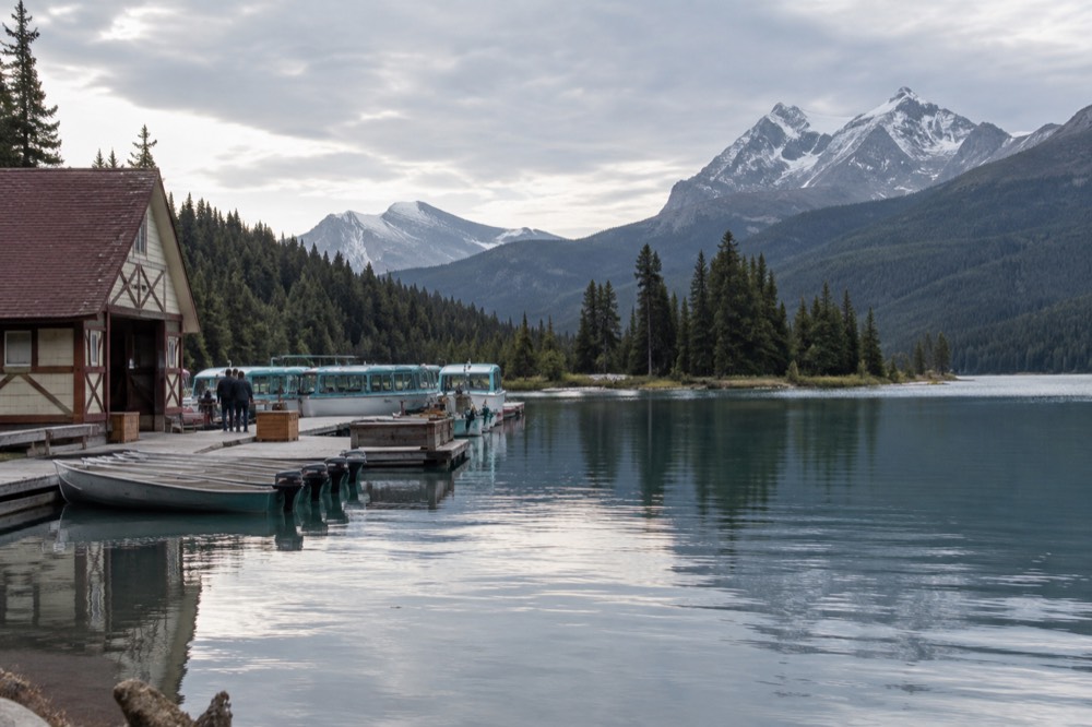 A calm mountain lake surrounded by forest with a small island near the shore
