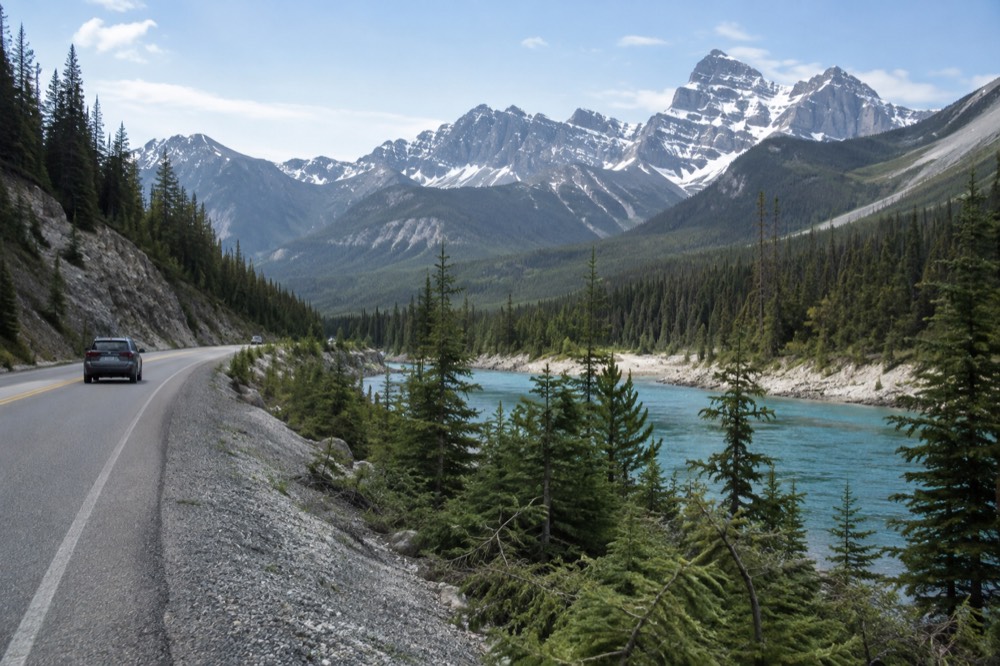 A winding road through a mountain valley beside a turquoise river