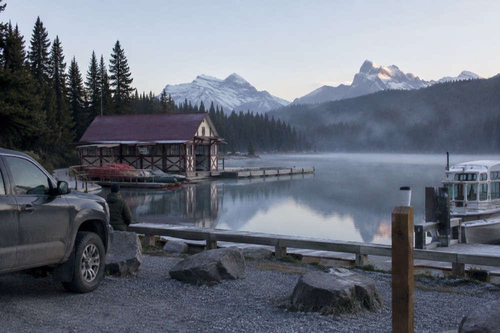 Morning mist over a mountain lake with reflections of forested slopes