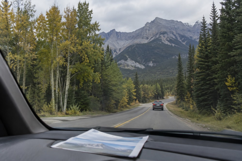 A park entry pass displayed on a car dashboard beside a mountain highway