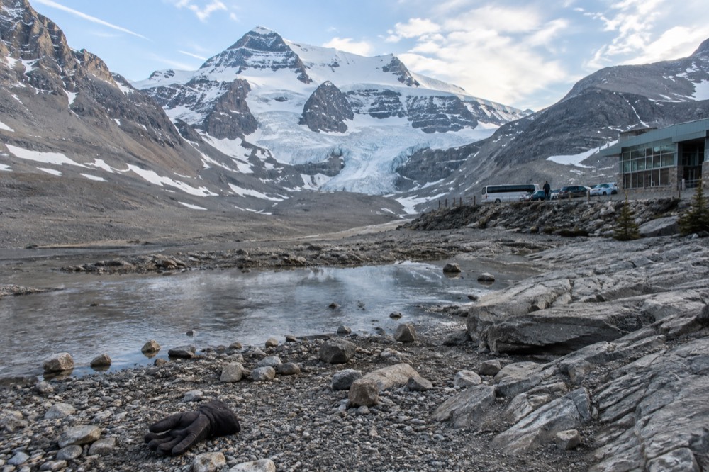 Steep mountain face with a glacier hanging in a bowl above a rock moraine